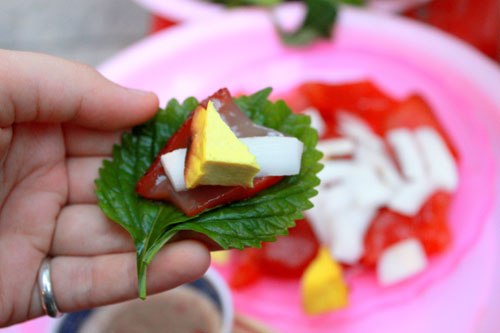 Khi ăn, bạn đặt sứa, đậu phụ và dừa non lên lá kinh giới và tía tô rồi cuộn lại.